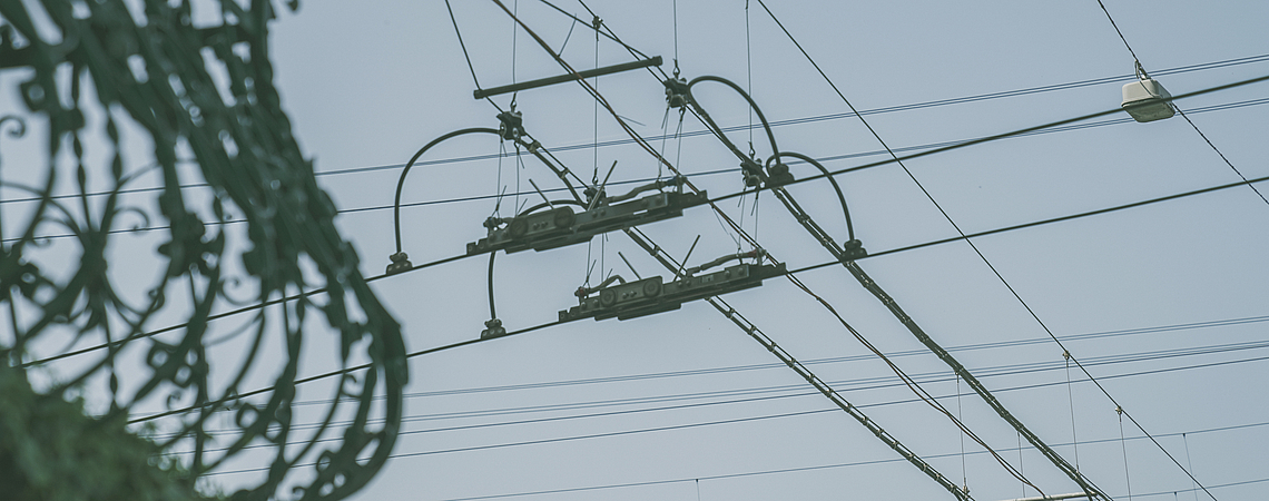 Fahrleitungen des Trolleybusnetzes in Luzern vor blauem Himmel.