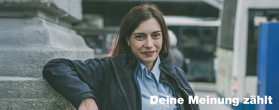 Porträt einer Busfahrerin der Verkehrsbetriebe Luzern. Im Hintergrund Bus und Billettautomat.